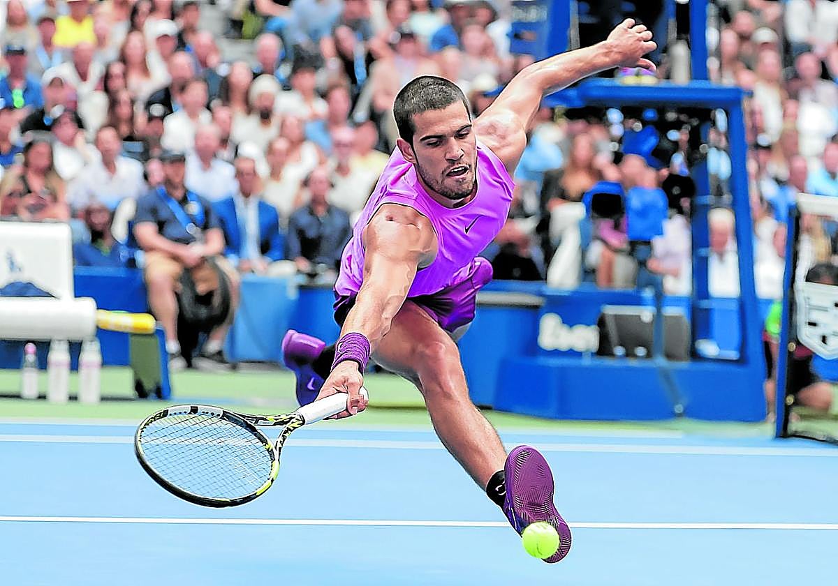 Carlos Alcaraz se estira para devolver una pelota en un partido en el que despachó en solo tres sets a uno de los mejores tenistas de la historia
