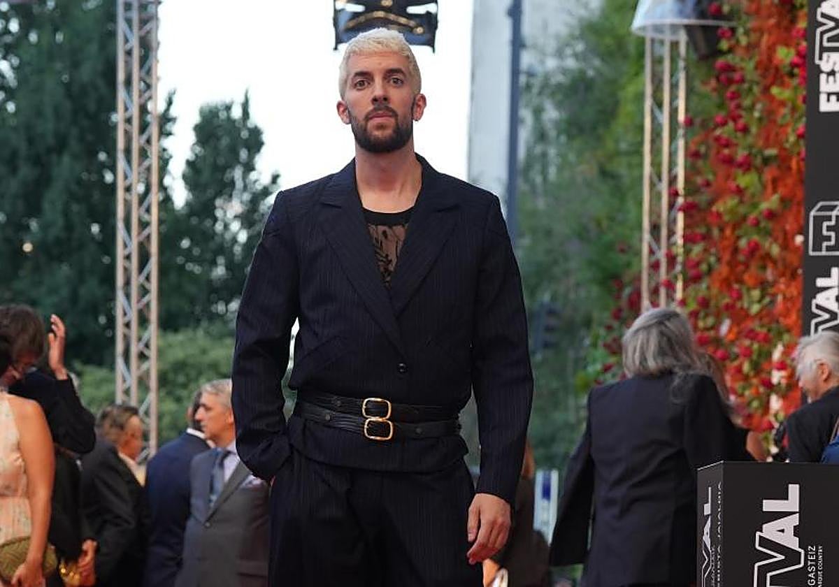 Broncano posa en la alfombra naranja.