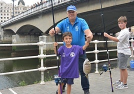 Urko, de seis años, posa con la primera captura del día con su monitor, José Luis.