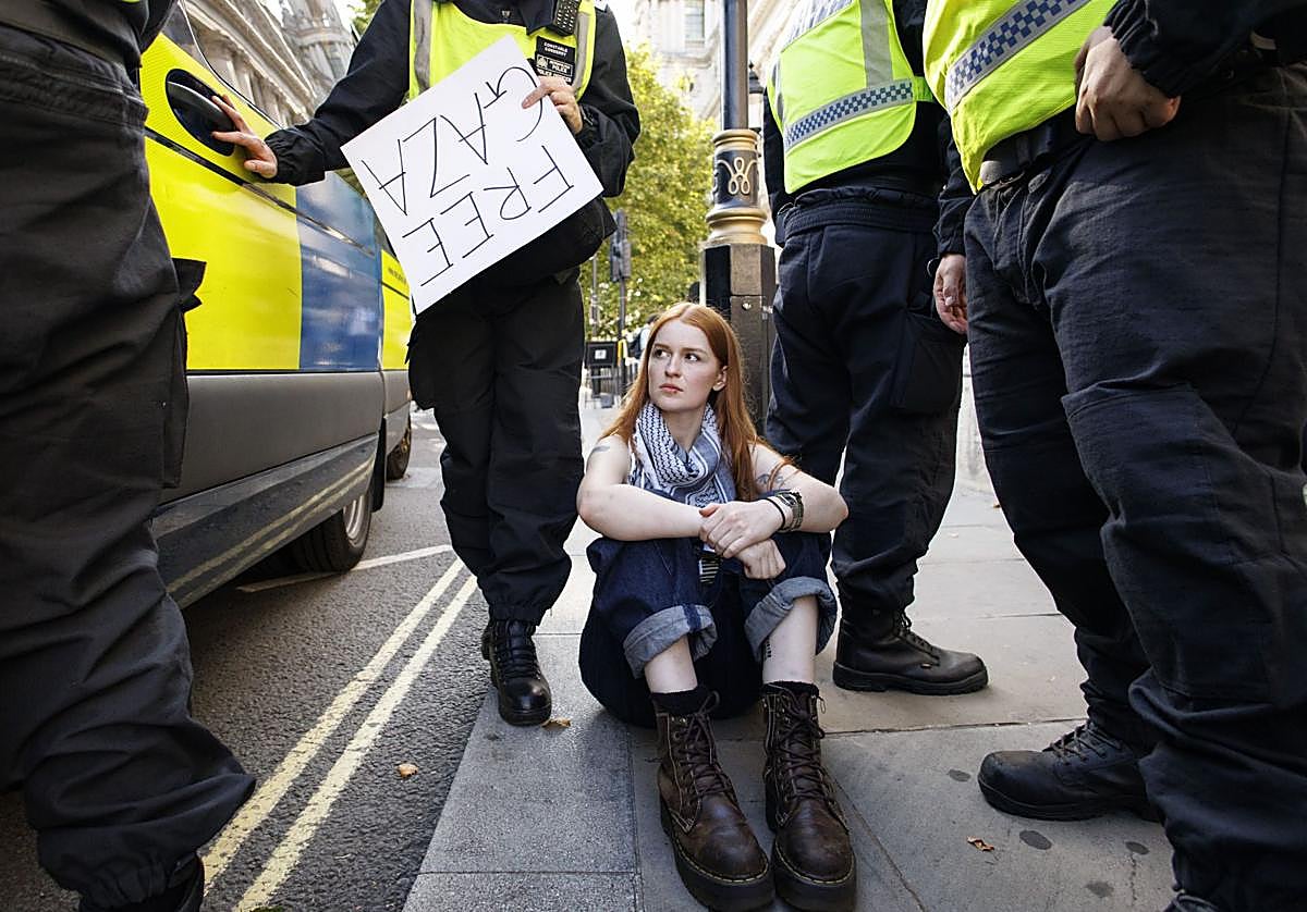 Agentes de policía arrestan a una partidaria de Palestine Action que asistía a una protesta masiva organizada por el grupo Defend Our Juries en Londres.