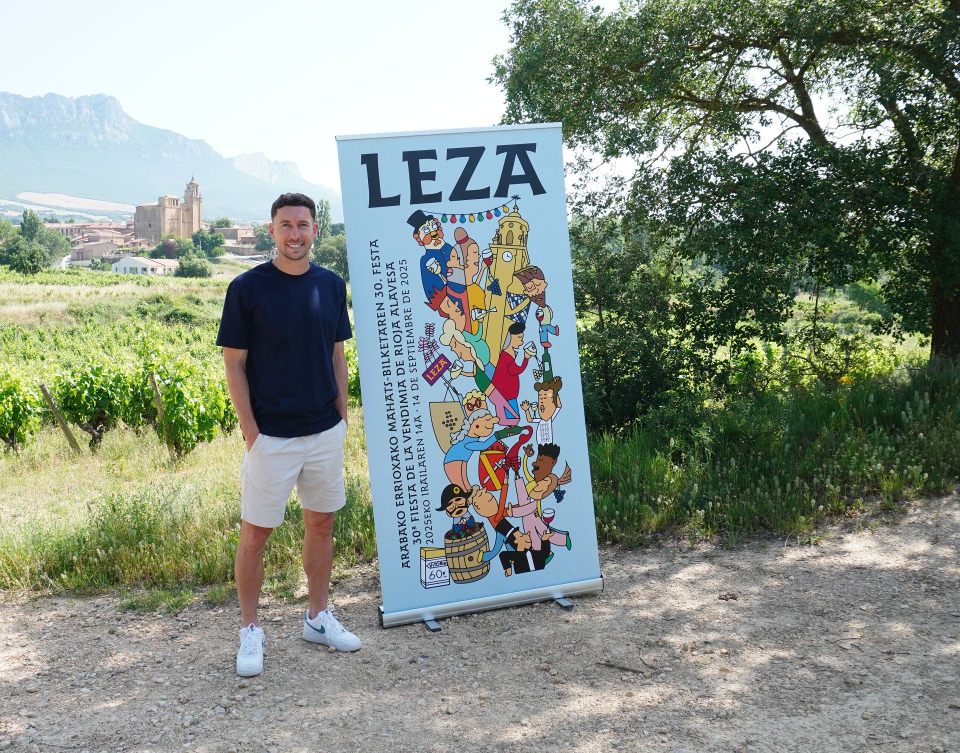 Óscar de Marcos, pregonero, posa junto al cartel anunciador de la fiesta.