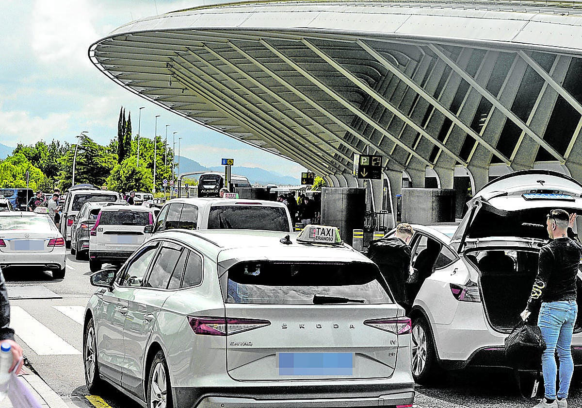 Taxistas recogen a turistas en la parada del aeropuerto de Loiu.
