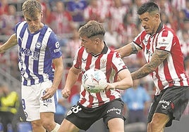 Jauregizar y Yuri Berchiche pelean un balón con Pablo Ibáñez en el centro del campo.