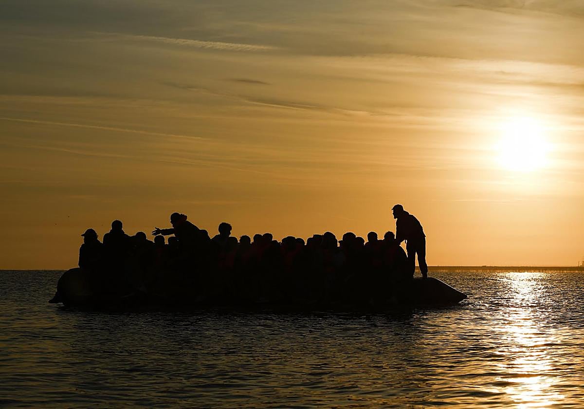 Migrantes suben a una lancha neumática para cruzar el Canal de la Mancha en Gravelines, norte de Francia.