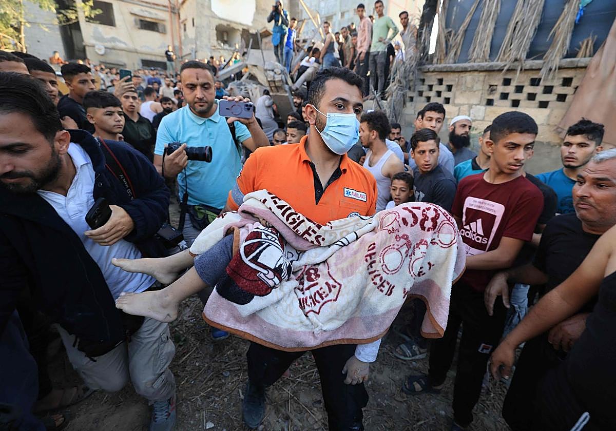 Un hombre sostiene el cadáver de un niño en Gaza.