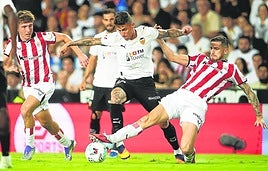 Oihan Sancet mete el pie para desviar el balón en un avance del valencia.