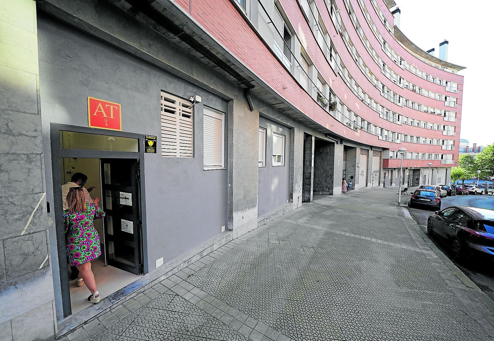 Varios turistas acceden a las inmediaciones de uno de los pisos turísticos ubicados en los bajos de una promoción protegida en Santutxu.