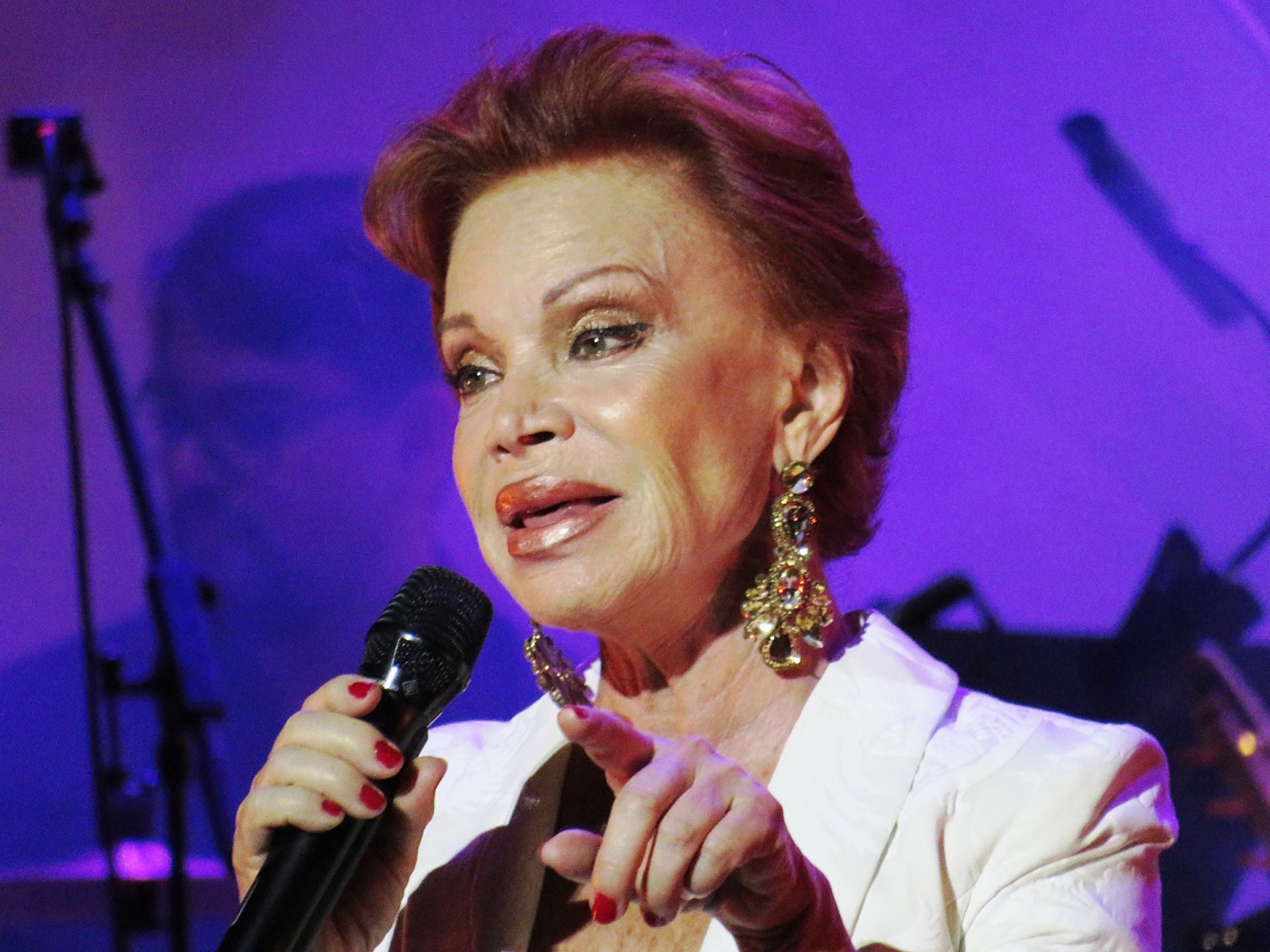 Paloma pastoreando al respetable, vestida de blanco.