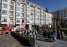 Los trabajadores desalojados, ante el edificio donde se ha producido un cortocircuito, foco del humo.