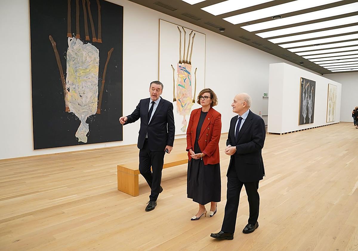 Miguel Zugaza, Elixabete Etxanobe y Gorka Martínez recorren la primera planta del edificio reabierto con las obras de Baselitz de fondo.