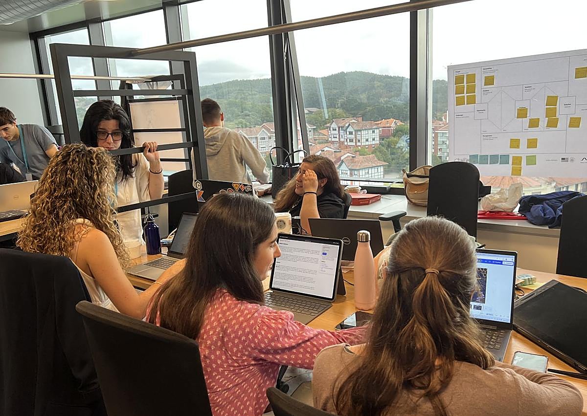 Imagen secundaria 1 - La directora del campus, Estibaliz León, junto al local lead del 'hackathon' en Bilbao, Rubén Concejo. Los participante strabajan en grupo para diseñar las soluciones a los retos propuestos.