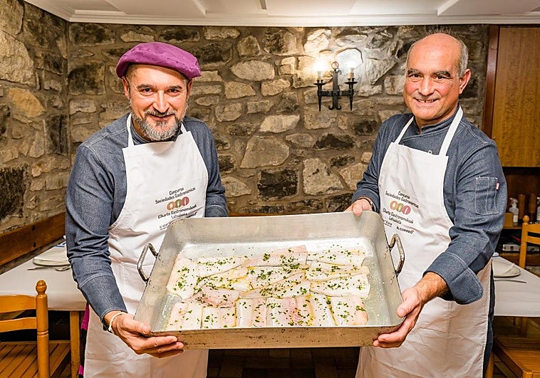 Sergio García, a la izquierda, y Armando Ochoa sostienen una cazuela con merluza. Sobre estas líneas, las alubias con el arroz frito, la panceta y las piparras y los saquitos de puerro con pollo dentro.