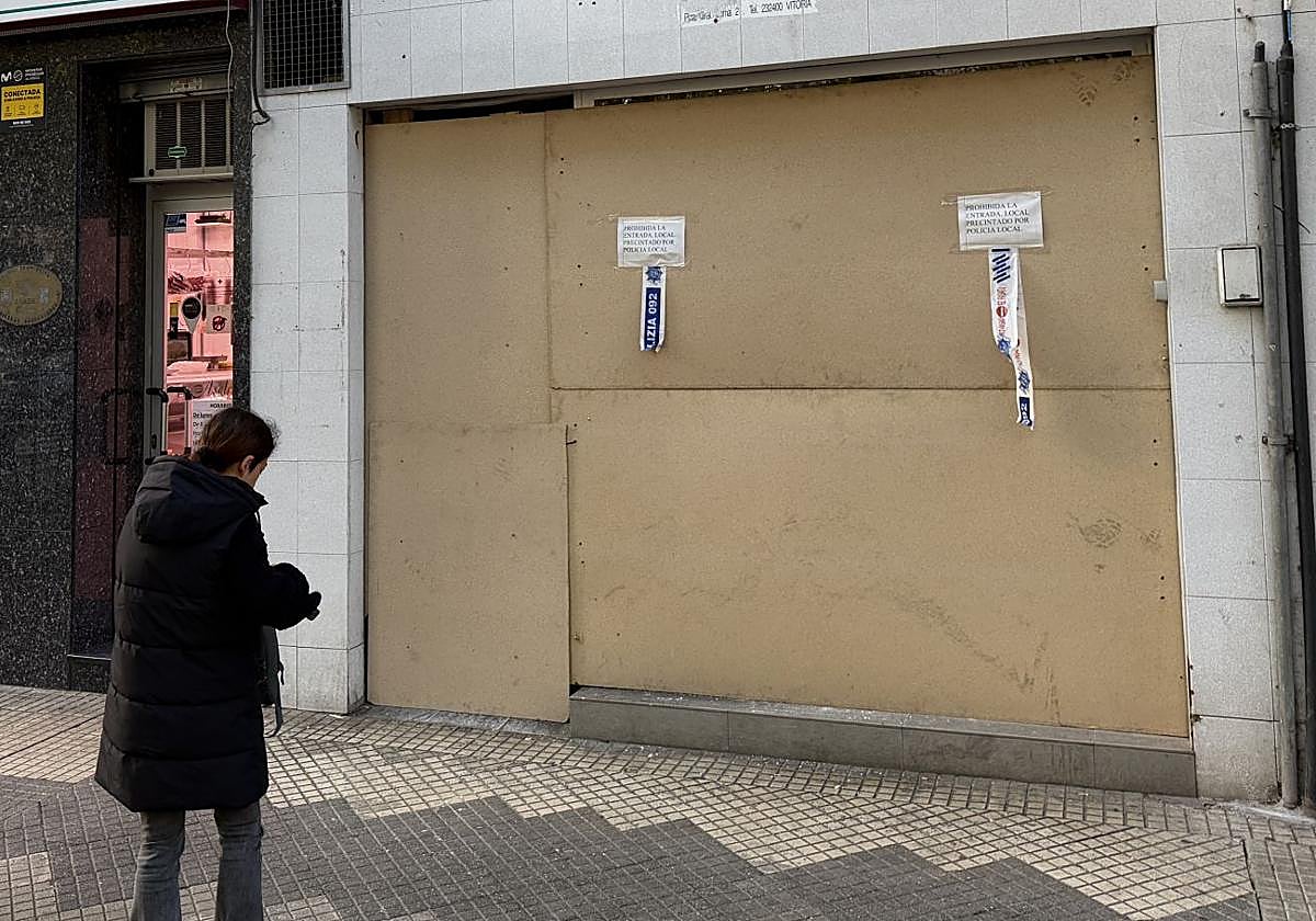 Una mujer observa los paneles que cubran la lonja recuperada por la Policía Local en la calle Nicaragua.