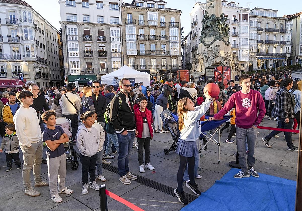 Una niña prueba su puntería en una canasta portátil.