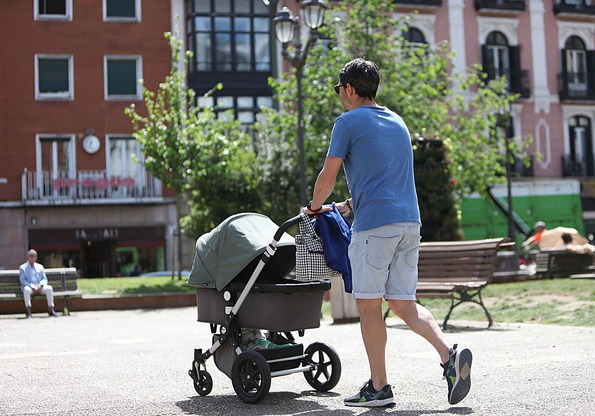 Un hombre pasea un carrito de bebé en Bilbao.