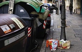 Una persona busca en un contenedor en Bilbao.