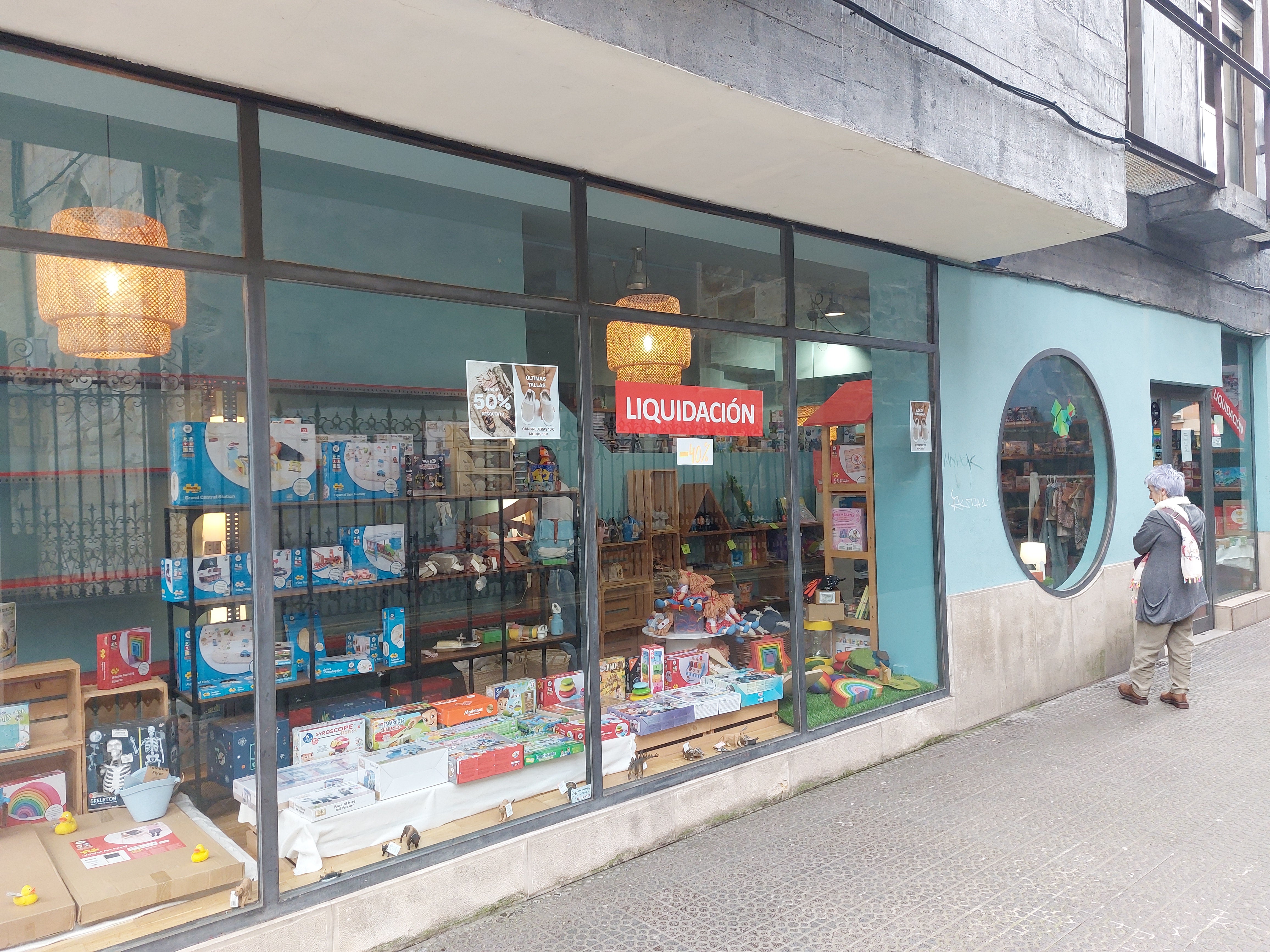 Una vecina observa el escaparate de juguetes, ubicada junto al casco viejo.