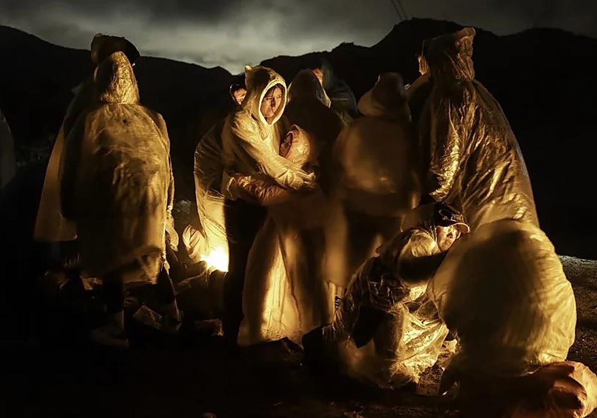 Imagen principal - Foto realizada por John Moore para Getty Images, que muestra a migrantes chinos calentándose bajo una lluvia fría tras cruzar la frontera entre Estados Unidos y México. Una imagen realizada por Musuk Nolte para 'Panos Pictures', que retrata el Amazonas convertido en un desierto. Y detalle de 'Más allá de las trincheras', de Florian Bachmeier.