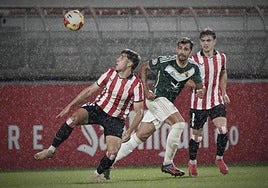 Eder García y Eñaut Lete rodean a Diego Gómez en un lluvioso partido.