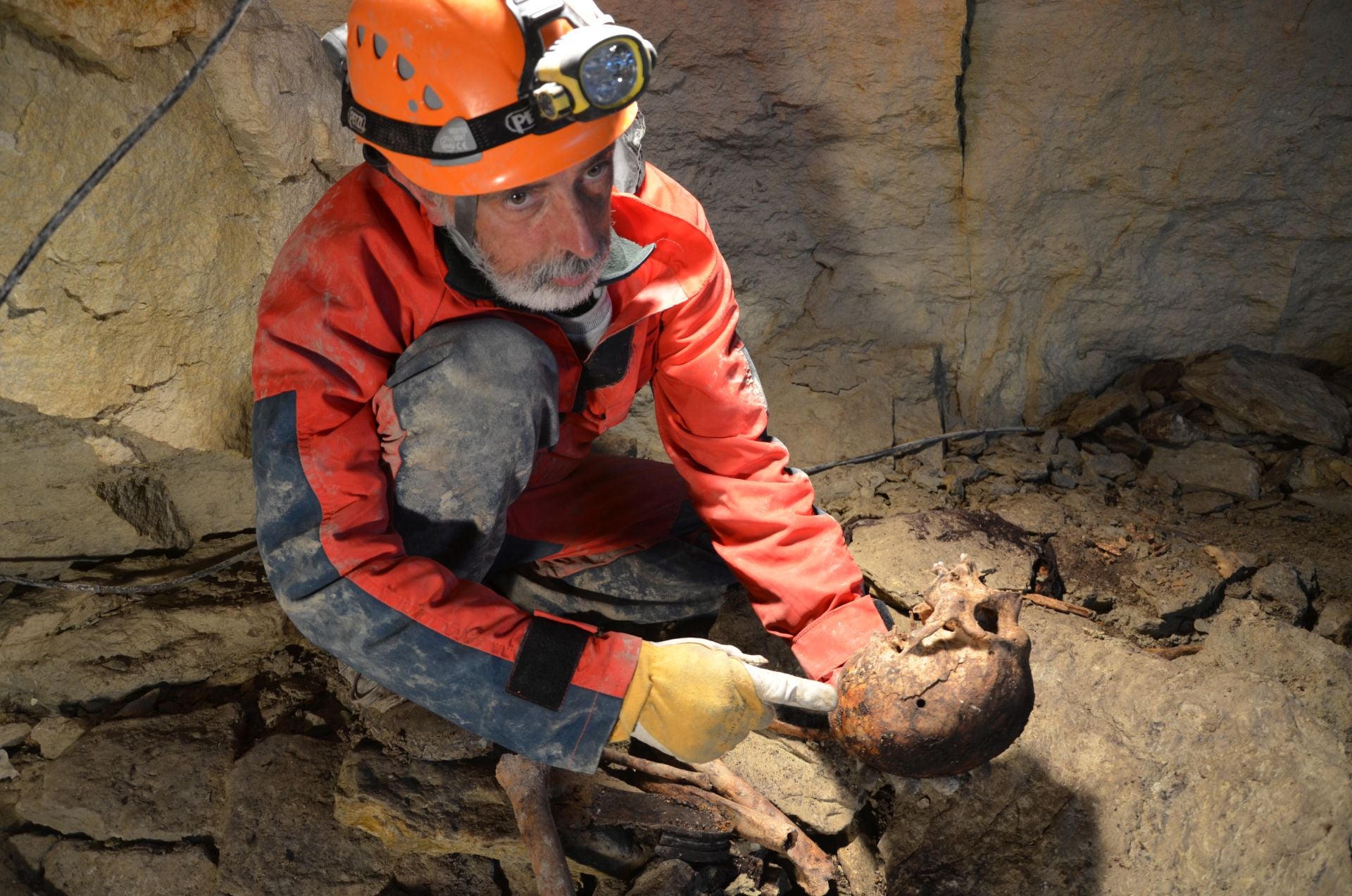 El forense Francisco Etxebarria enseña un cráneo con orificio de bala en la Sima el Raso, en Urbasa (Navarra).