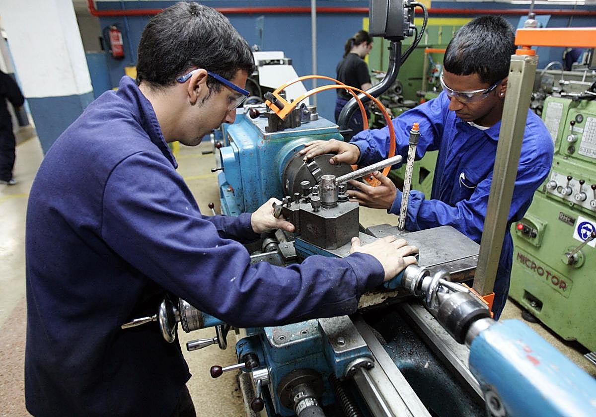 Alumnos de mecanizado durante unas prácticas en una empresa.