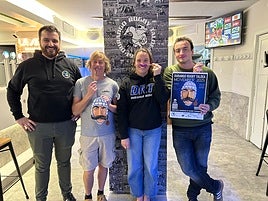 Miembros del club posan con los bigotes y el cartel de la iniciativa solidaria.