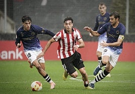 Iker Alday conduce un balón ante la oposición de Hugo de Bustos y Carlos de la Nava.