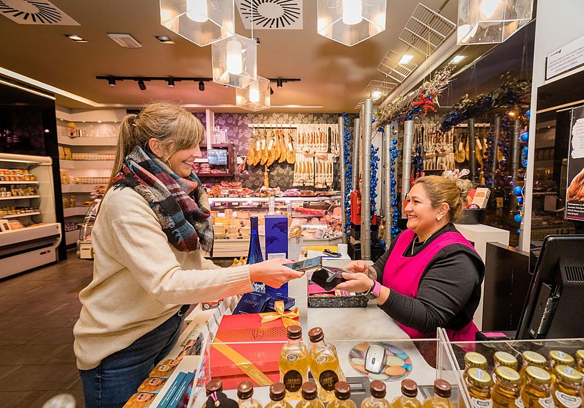 Una clienta abona su compra en Delicatessen La Blanca, en Zabalgana.