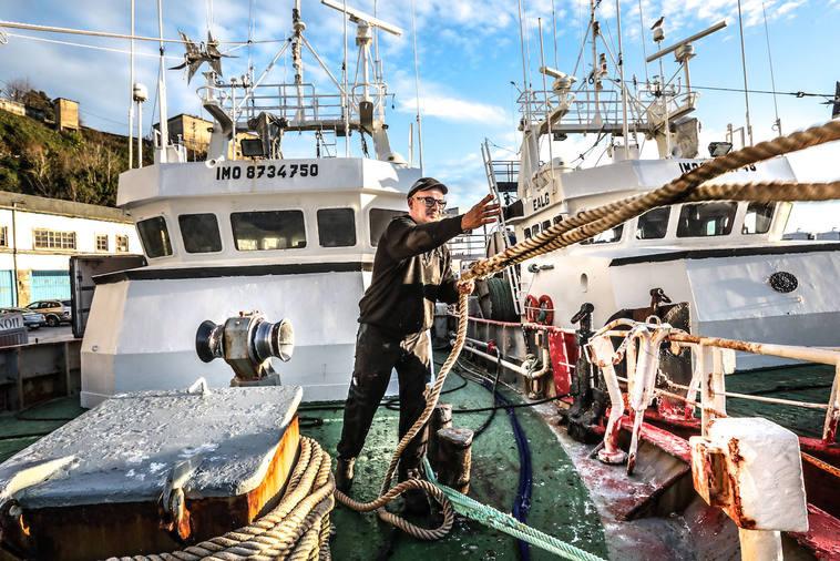 Un marinero lanza el cabo para amarrar en el puerto de Ondarroa uno de los barcos de altura.