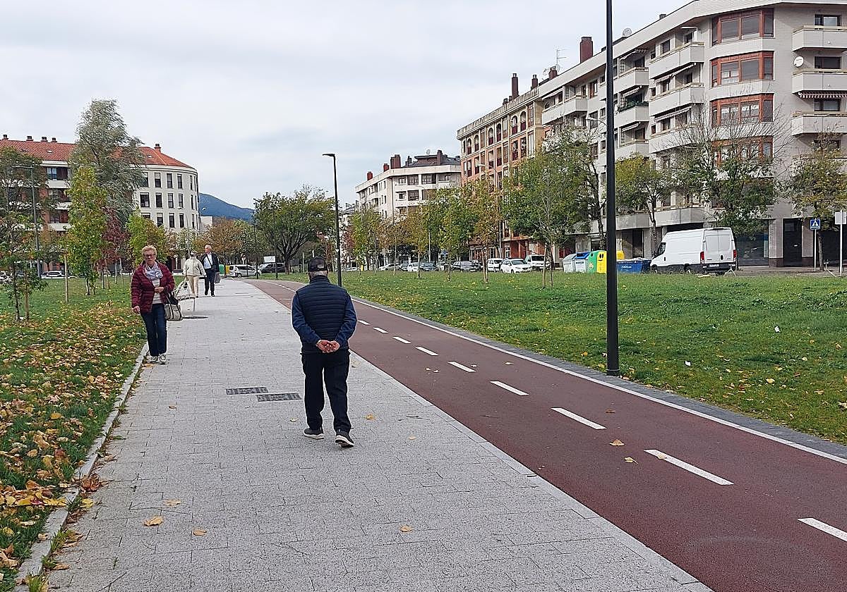 Unos vecinos caminan por la zona verde del bidegorri de Landako