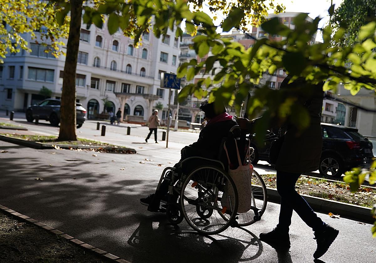 Una mujer y su cuidadora pasean por el centro de Bilbao.