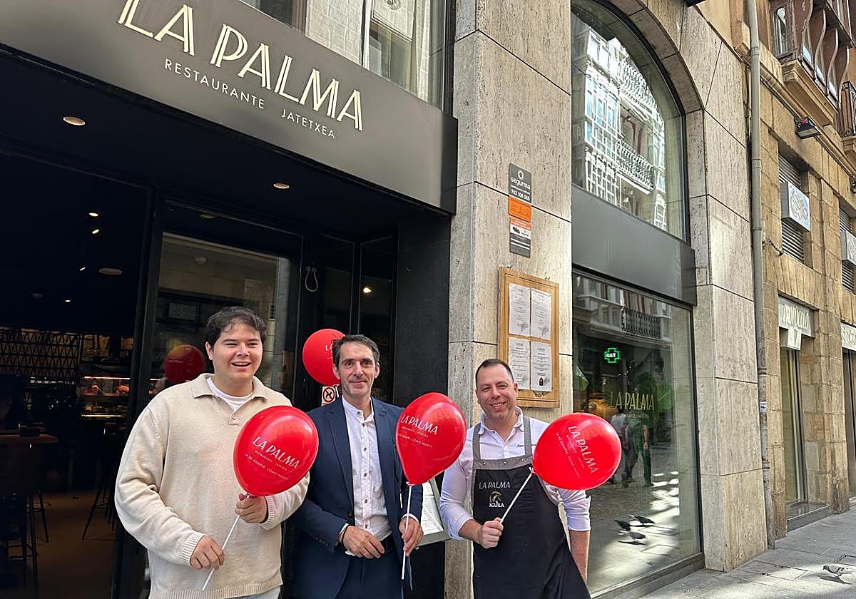 Jon Ander Martín, responsable de redes sociales; José Bernardo Flórez, encargado del restaurante; y Aitor Fernández, jefe de cocina, posan con los globos rojos de La Palma, que se van a empezar a repartir este viernes.
