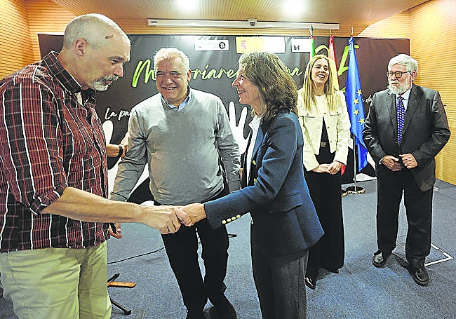 Marisol Garmendia estrecha la mano de Imanol Zubero en el acto impulsado por la Delegación del Gobierno por elDía de la Memoria.