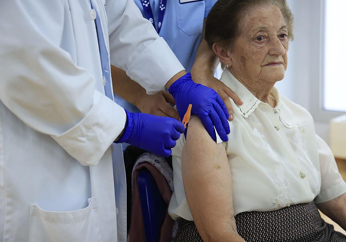 Una mujer recibe la vacuna de la gripe.