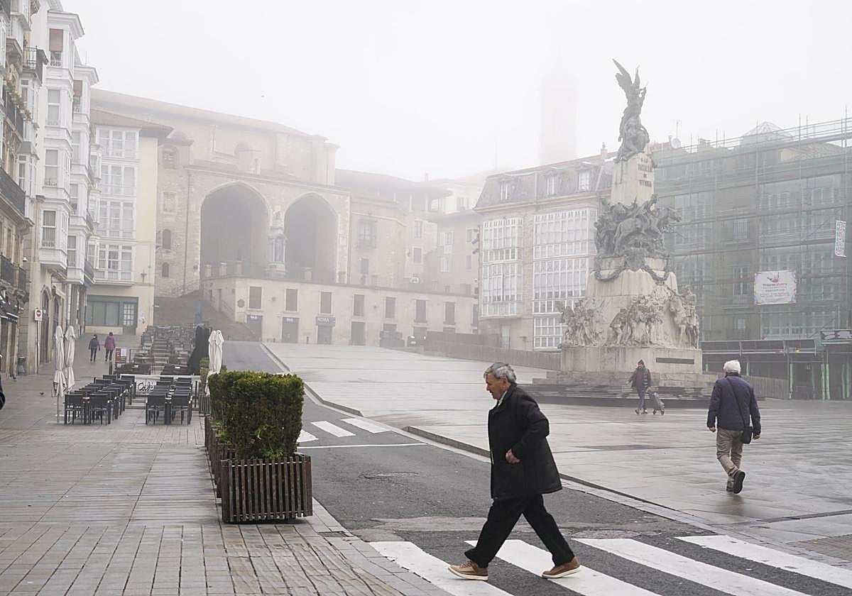 La plaza de la Virgen Blanca envuelta en niebla este domingo.