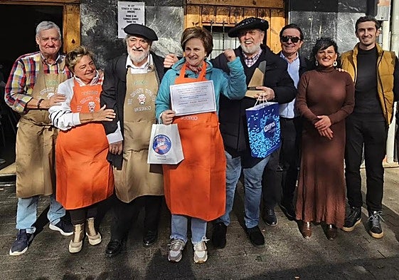 Rosi Gerekaetxebarria, junto a su marido, con la txapela de ganador, alza el puño en señal de triunfo tras recibir el premio a la mejor morcilal de verduras de San Martin, en Bermeo.