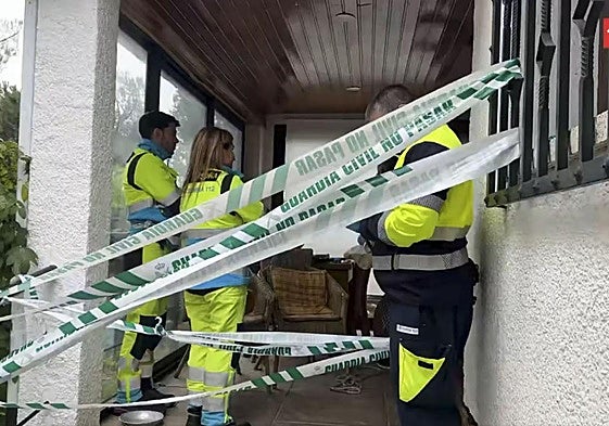 Varios sanitarios, en la entrada del chalé donde aparecieron los dos cadáveres.