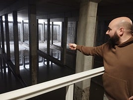El concejal Guillermo Ubieto observa el depósito en el que se acumula el agua de lluvia