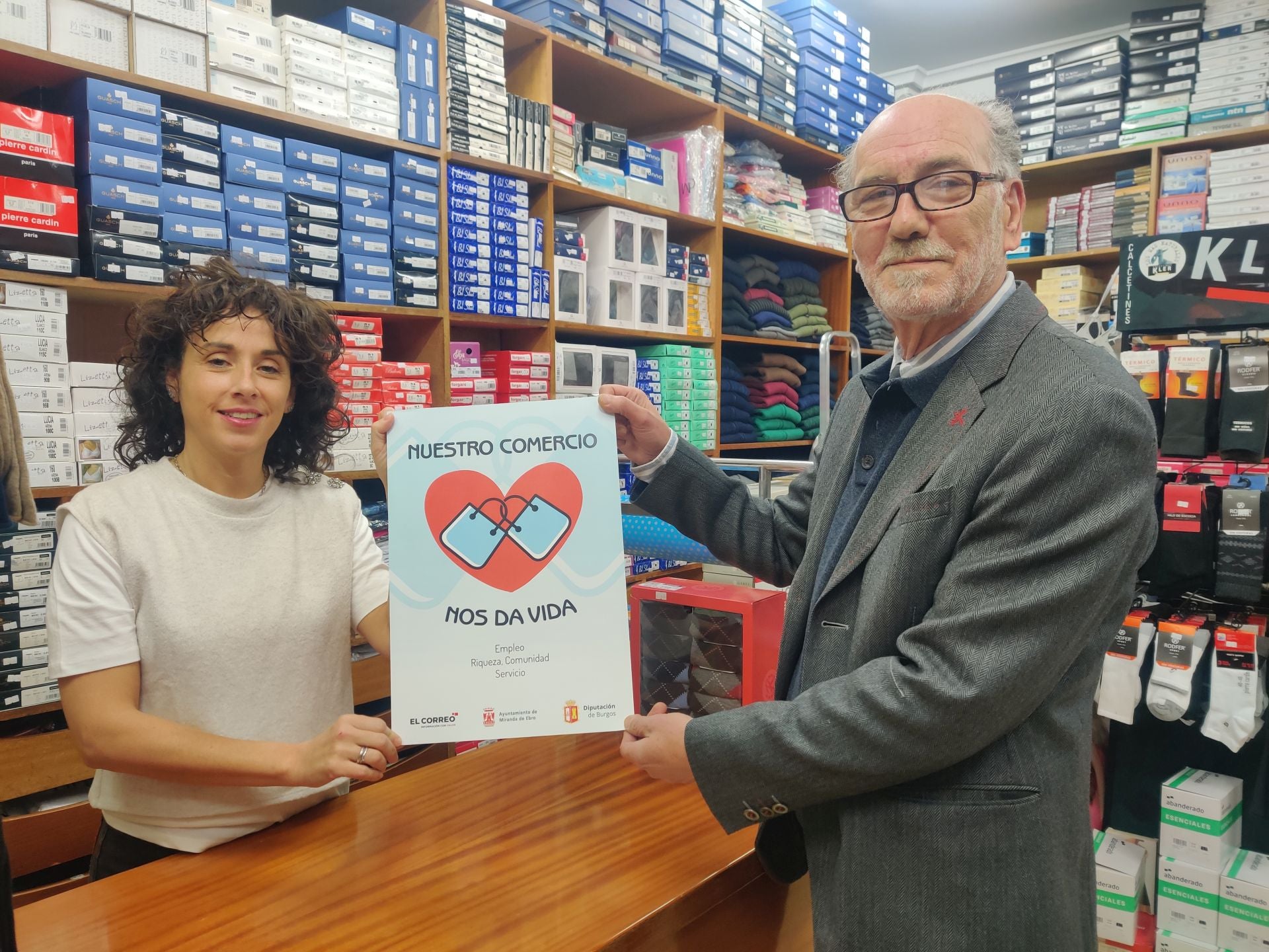 Imagen secundaria 1 - Jorge Castro, el diputado provincial, con el responsable de Carnicería Mariló, Miguel Ángel Adrián, concejal de Promoción Económica, en Resines; y otro cartel más con corazón en Amelia Complementos.