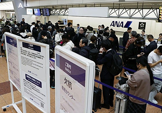 Los pasajeros hacen cola en el mostrador de cancelaciones de ANA (Japón) después de que la compañía anunciara retrasos.