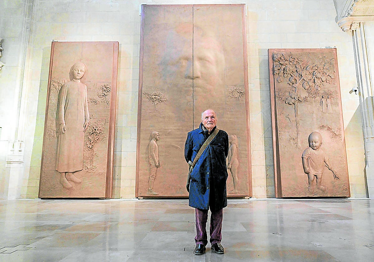 Antonio López, ante las puertas concebidas para la catedral, con las imágenes de la Anunciación, la Creación y la Encarnación (Niño Jesús).