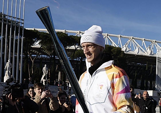 Polonara, sonriente con la antorcha olímpica.