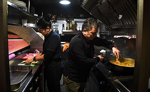 Eneko y Adriana Pereira trabajan en la cocina.