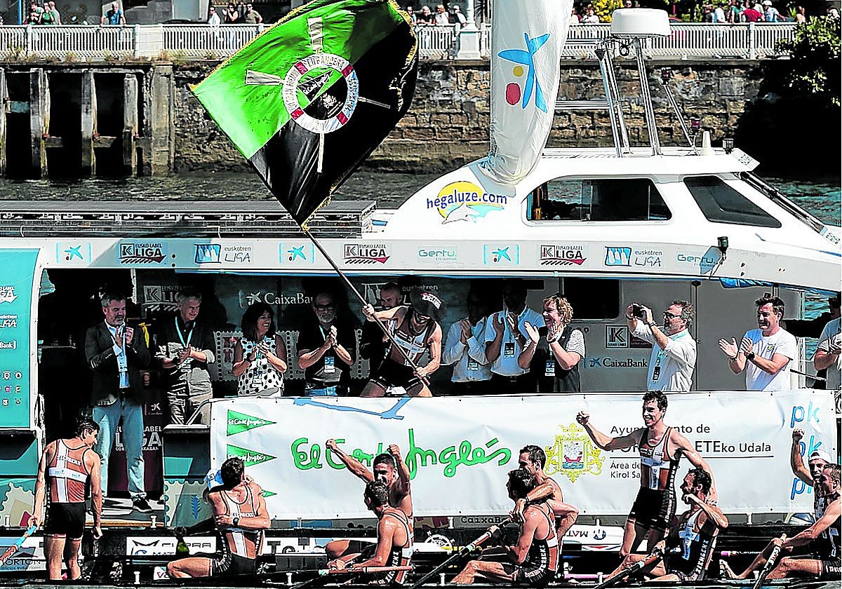 El patrón de Zierbena Aitor Lazkano ondea la Bandera El Corte Inglés en el barco de autoridades.