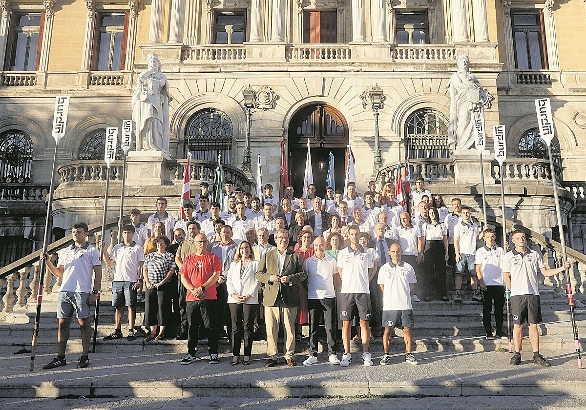 Plantilla, cuerpo técnico y patrocinadores de Deusto posan junto a la corporación en las escalinatas del Ayuntamiento de Bilbao.