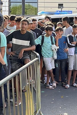 Un grupo de menores espera a ser identificado a las puertas de una comisaría en Ceuta.