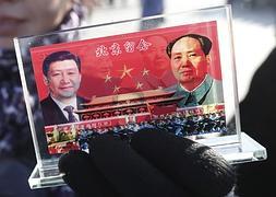 Un vendedor expone un recuerdo con la imagen del presidente chino, Xi Jinping, y del fallecido líder Mao Zedong. / Efe