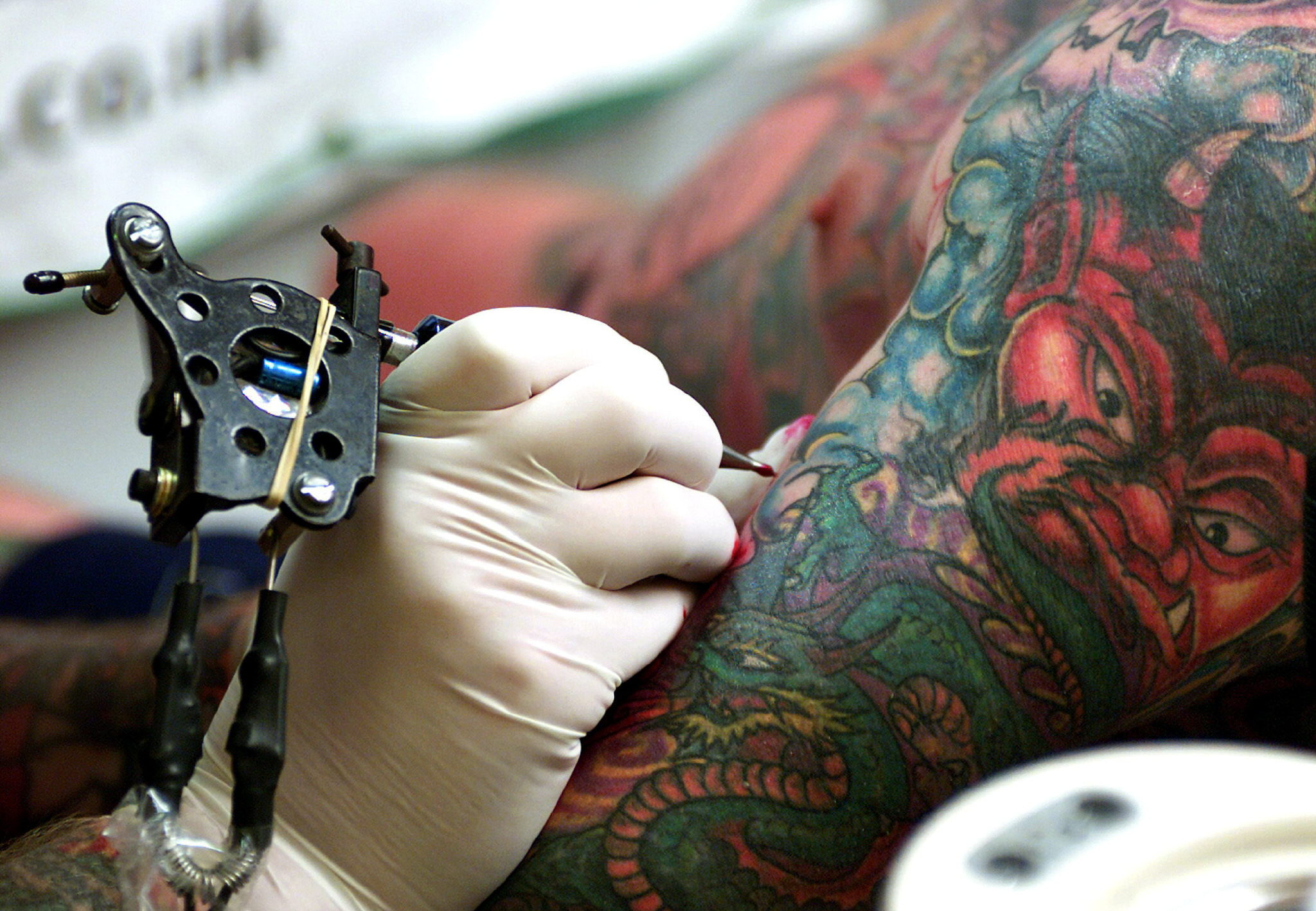 Tatuador retoca un tatuaje. 