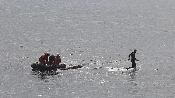 Efectivos de Salvamento Marítimo intentan el rescate del inmigrante. 