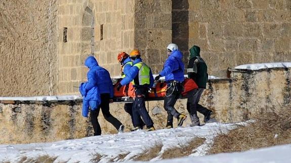 Miembros de los servicios de emergencias trasladan a uno de los fallecidos. 